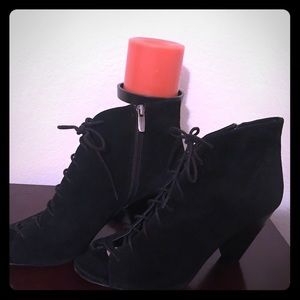 Black suede, lace up ankle booties with peep toes.